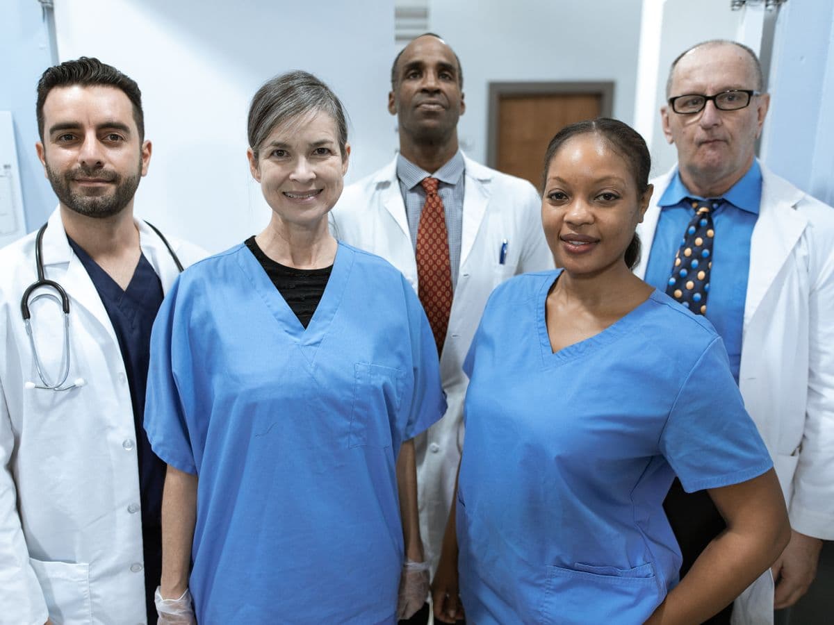 A diverse team of doctors and nurses standing together in a hospital