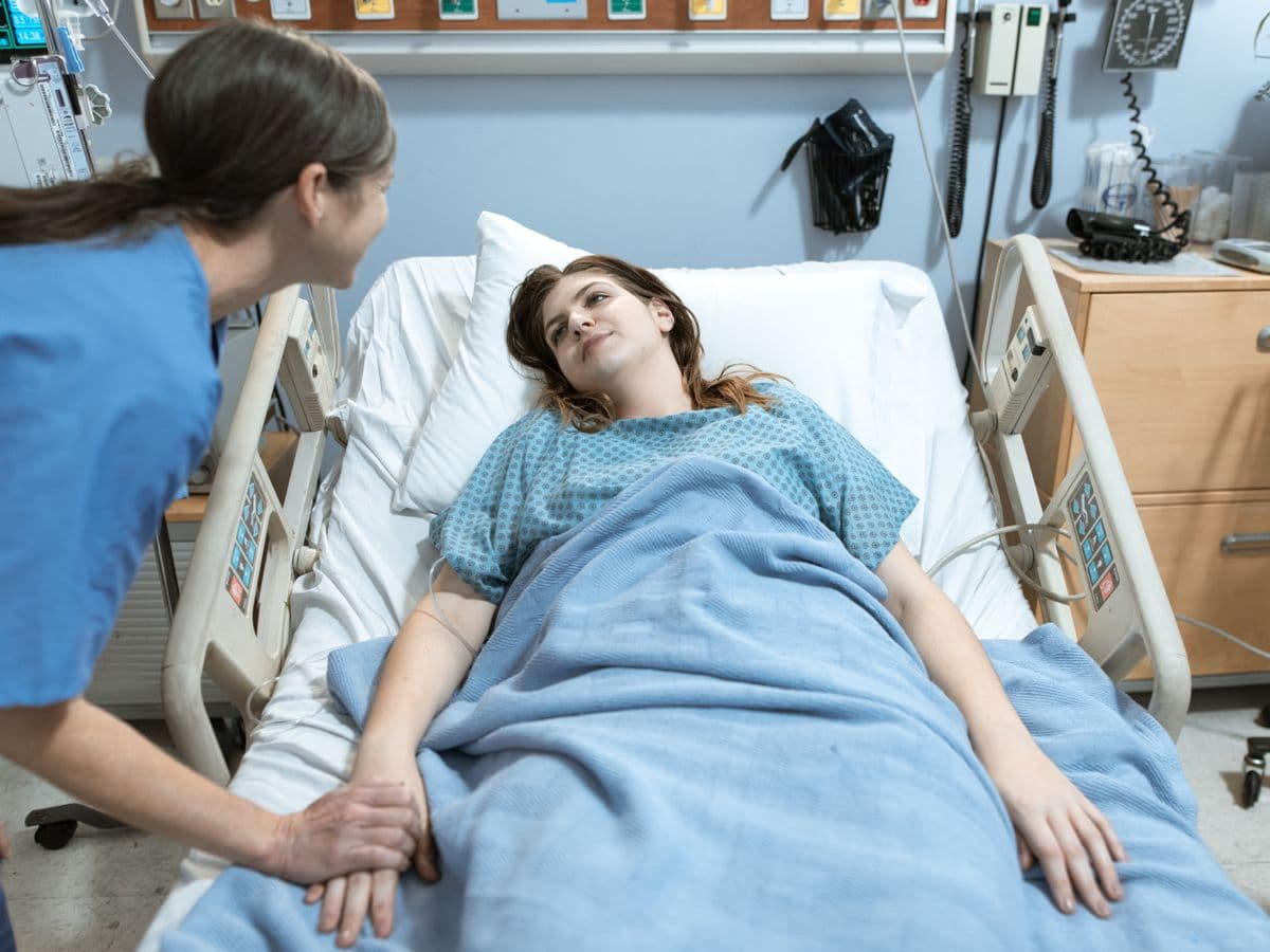 A nurse communicating warmly with a patient at the bedside